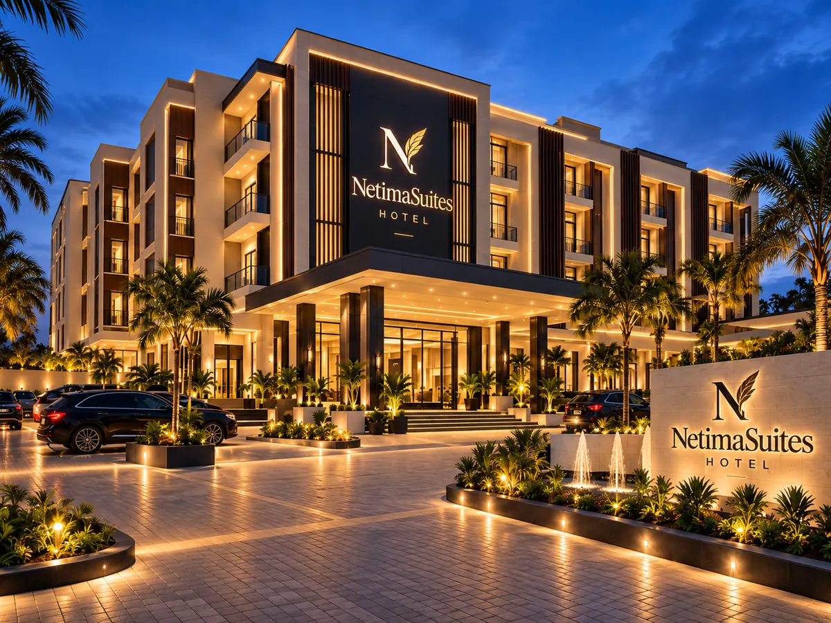 The proposed NetimaSuites exterior, illuminated in cream and charcoal with landscaping and vehicle arrival area